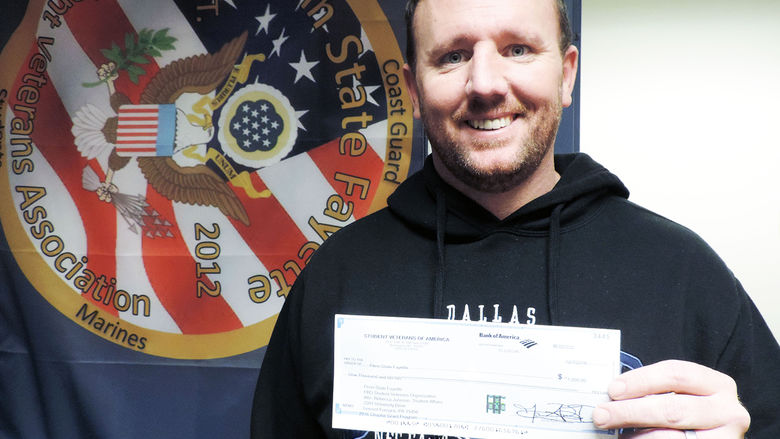  Dan Sparks, president of the Student Veterans Association at Penn State Fayette, The Eberly Campus, displays a $1,000 check for a chapter grant his organization recently received from Student Veterans of America.