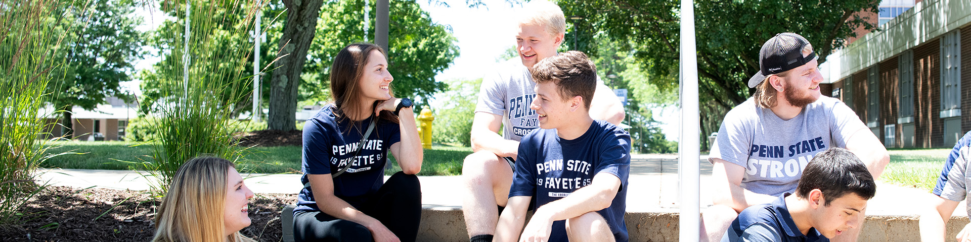 Students sitting on the steps to the Eberly Building.