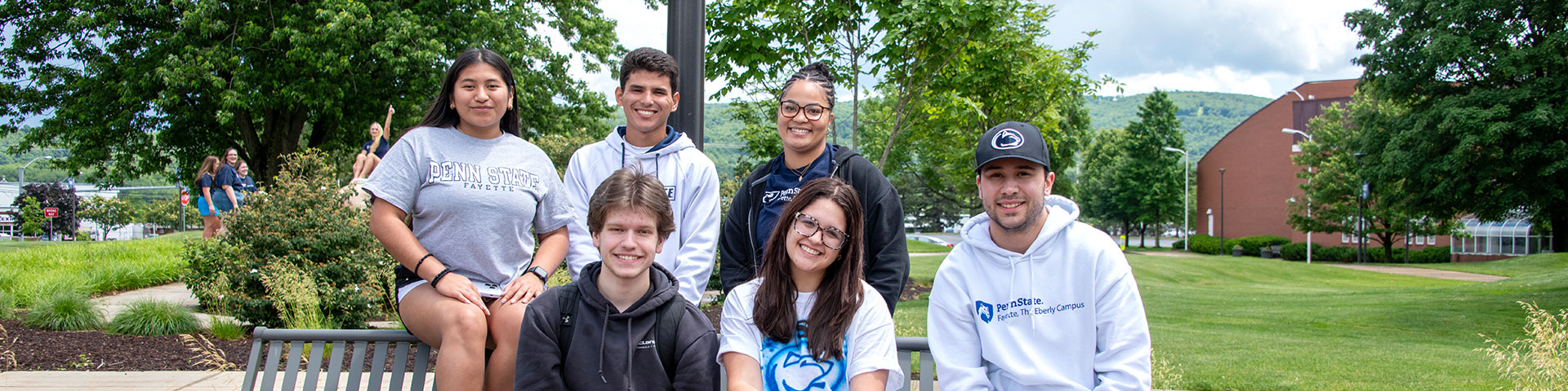 Students sitting a bench on campus.