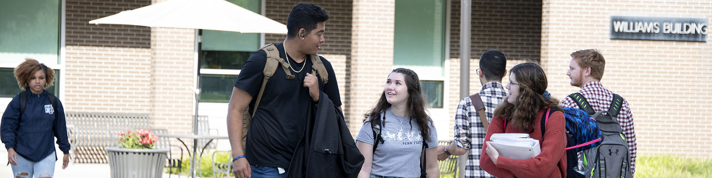 Student walking in front of the Williams Building. 