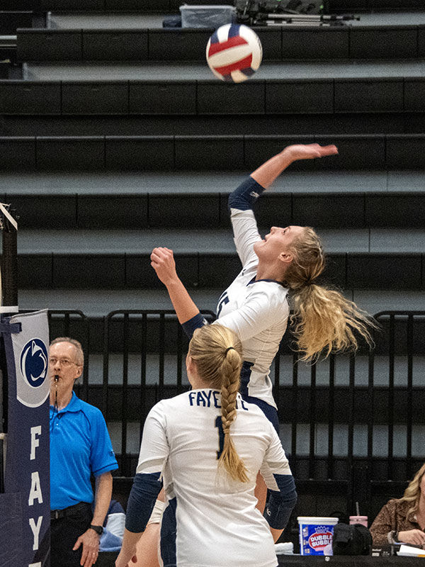 Volleyball player hitting the ball over the net. 