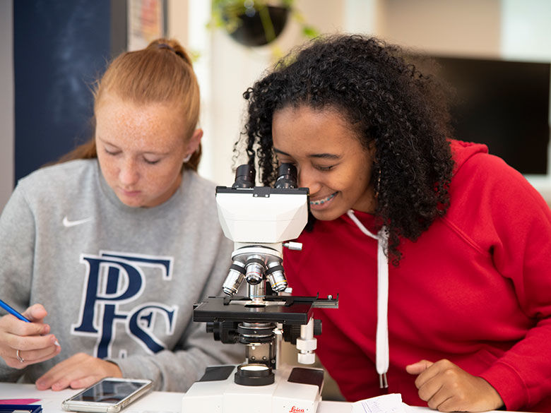 Two students using a microscope.