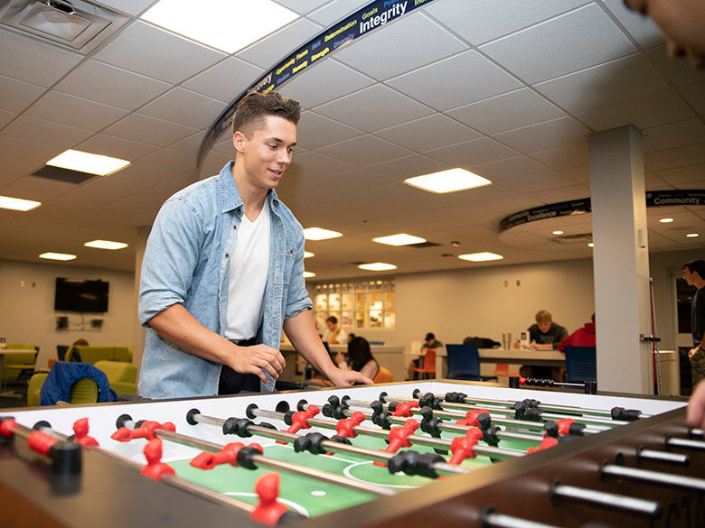 Student playing fuzzball in the Student Center.