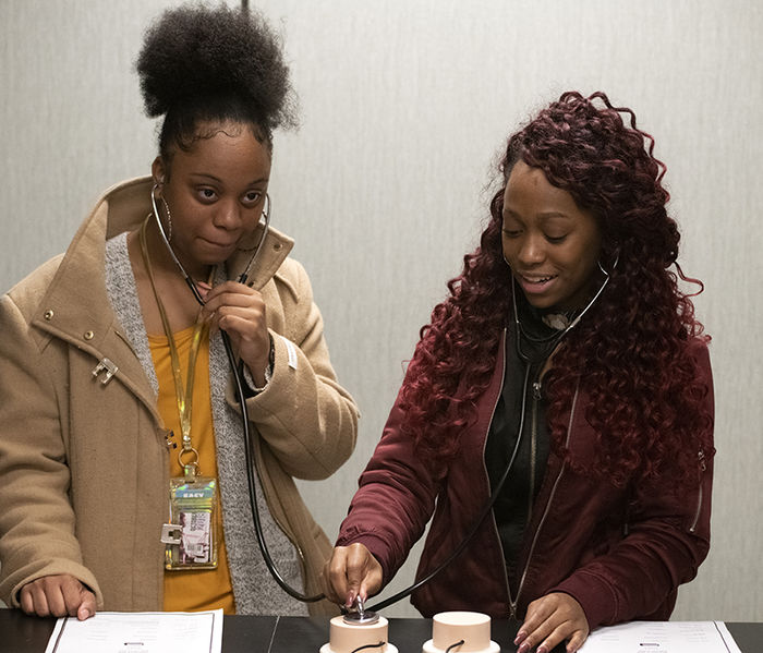 Caption 2: Laytara Burrel and Breonna Willias participate in a stethoscope demonstration.