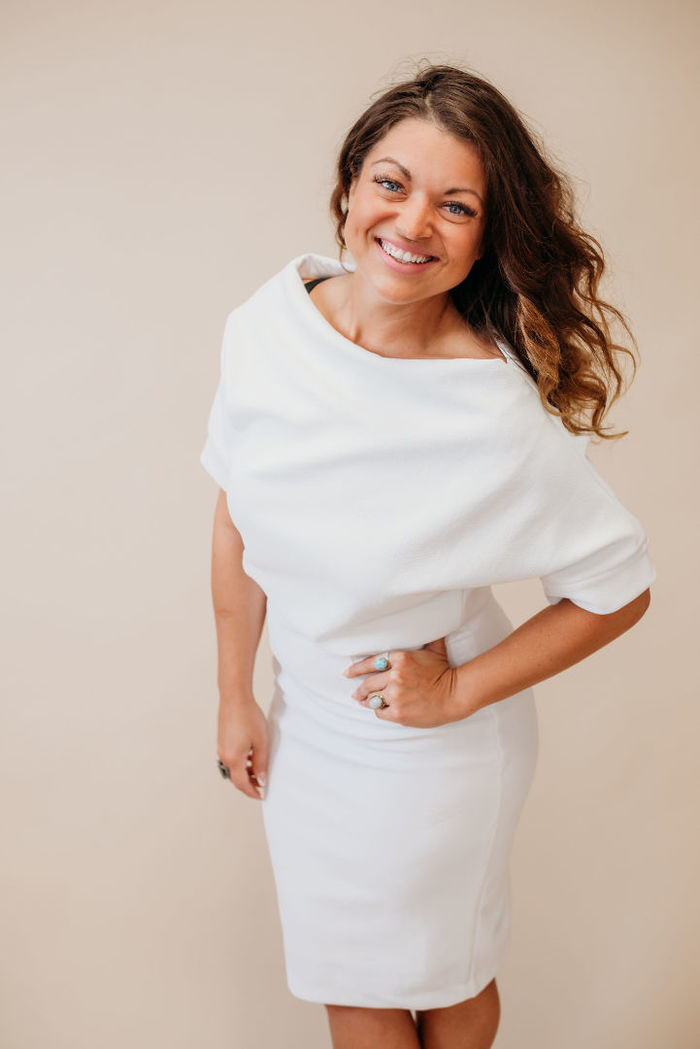 Rebecca Corvin poses in a white dress