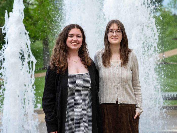 Two Penn State Fayette students stand smiling in front of the campus fountain following the Student Awards Banquet.