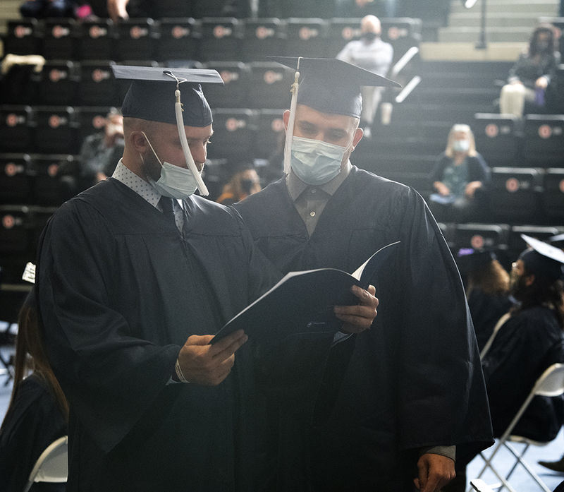 Graduates look over the commencement program