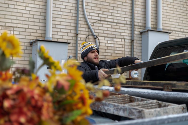 Male student loads truck with ladder Male student load truck with ladder
