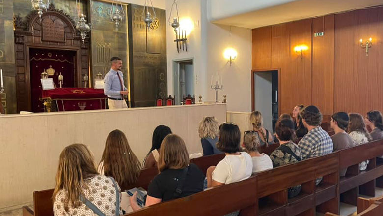 Students sit in pews during a lecture on the psychology of religion as part of their study abroad curriculum.