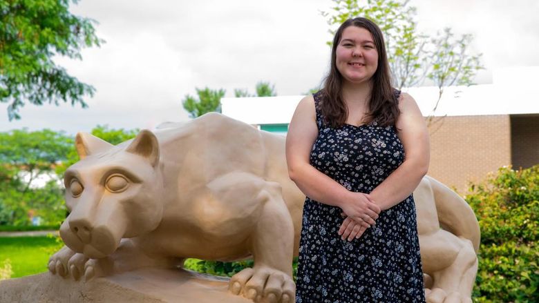 Olivia Spotto posing in front of the Penn State Fayette lion shrine.