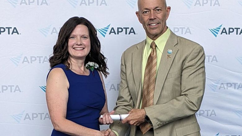 Pamela Pologruto standing beside Roger Herr, award in hand.