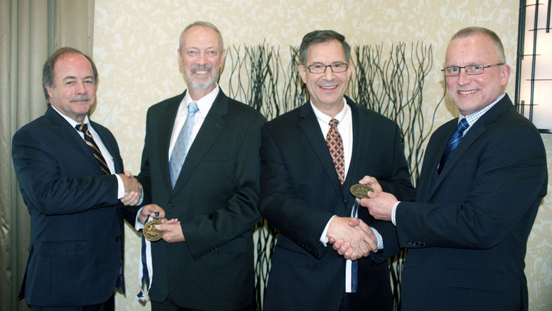 Outstanding Fellow Robert Eberly Jr. (second from left) Outstanding Alumnus Mark Kempic (third from left) receive medallions from Advisory Board of Penn State Fayette Inc. Chair Gary Monaghan (left) and Dr. Charles Patrick, chancellor and cao.