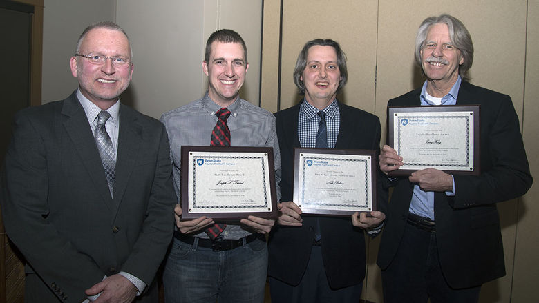 Chancellor and Chief Academic Officer Dr. Charles Patrick presented, from left, Joseph Friend Jr., Nathaniel Bohna, and Dr. Jerrold Hoeg with plaques for the Staff Excellence, Ellen Laun Advising Excellence, and Faculty Excellence awards, respectively.