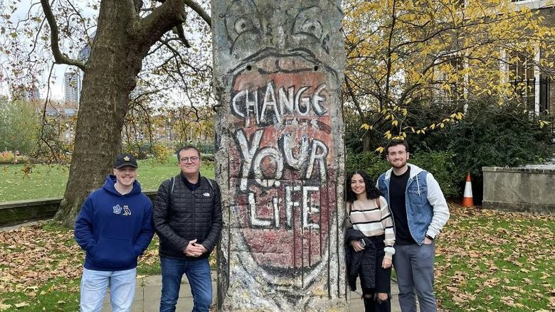 Students of the course CRIMJ 499 Serial Killers and European Criminal Justice next to a piece of the Berlin Wall.