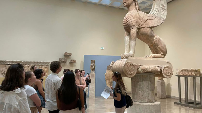 Students examine Ancient Greek artifacts in Athens, Greece, as part of their study abroad experience.