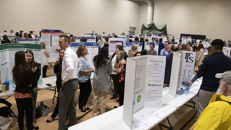 Students, faculty, and staff gather at the Spring 2022 Learning Fair in the auxiliary gym