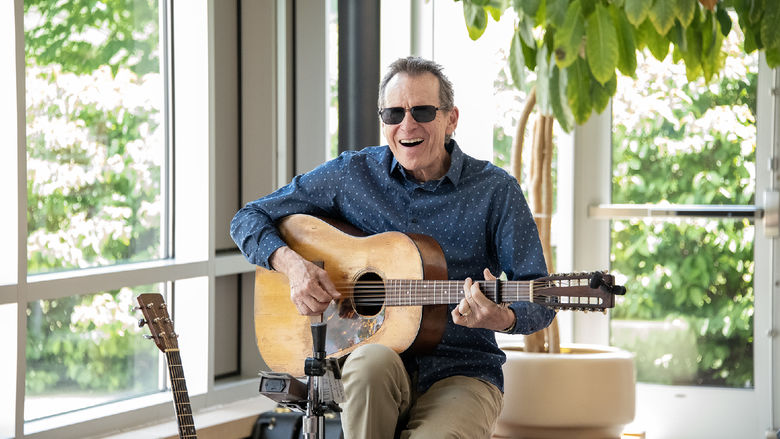 Smiling guitarist plays live music.