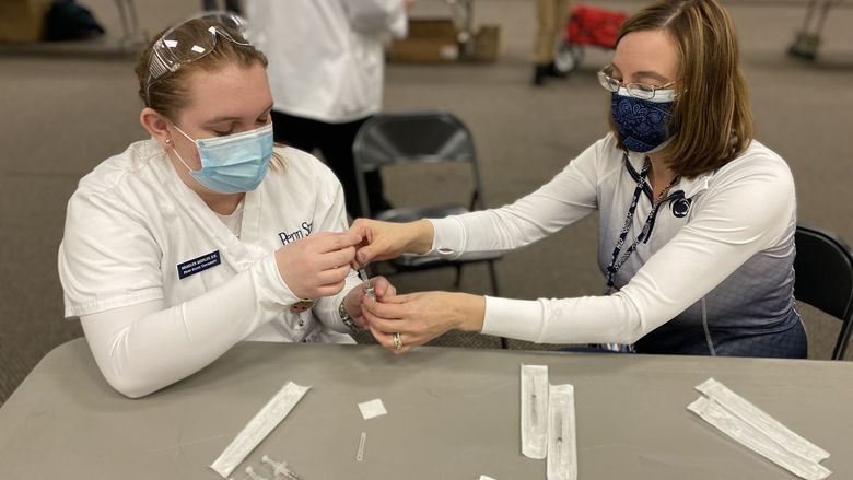 Sophomore student Shaelynn Shipley draws up a vaccine under the supervision of instructor Alison Hawk.