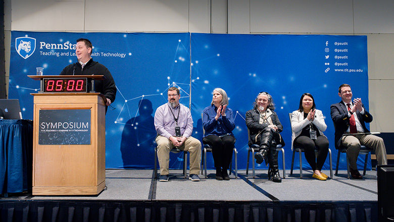 Five Open Innovation Challenge finalists are seated on stage as they wait to present their ideas