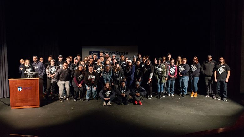 Students take group photo on stage
