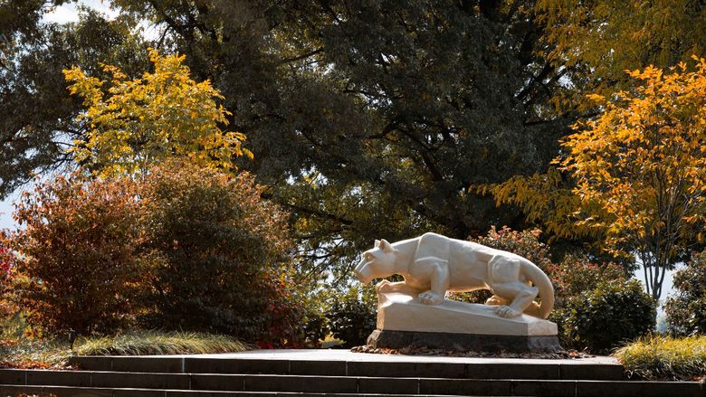 The Nittany Lion Shrine at Penn State Fayette stands surrounded by foliage.