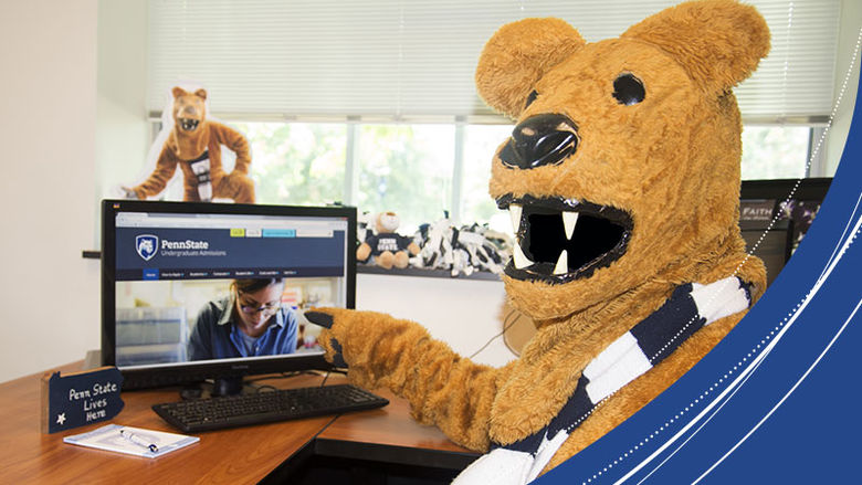 Lion mascot working on a computer. 