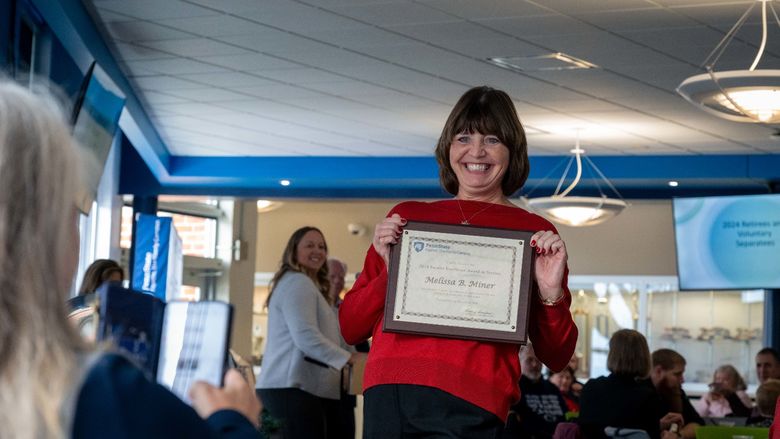 Melissa Miner smiles with her Faculty Excellence Award.