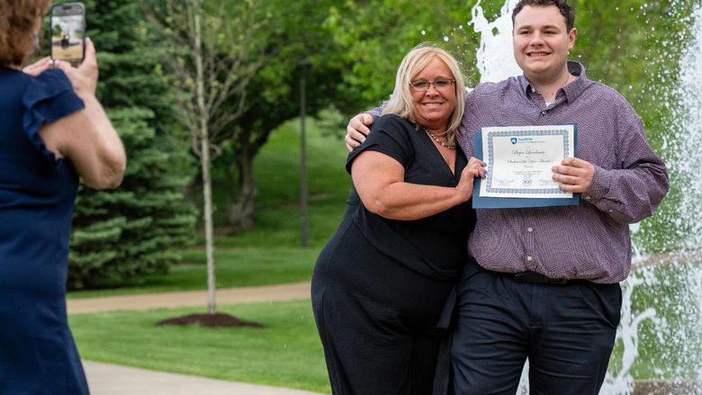 Bryce Landman poses with family by the fountain after receiving the Student of the Year award in Business at Penn State Fayette.