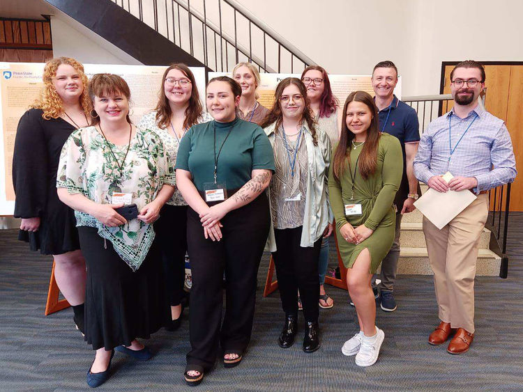 Students standing alongside their faculty mentors at the research conference.