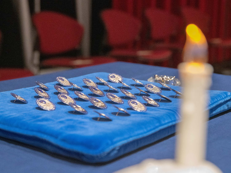 Nursing pins stationed by a candle.