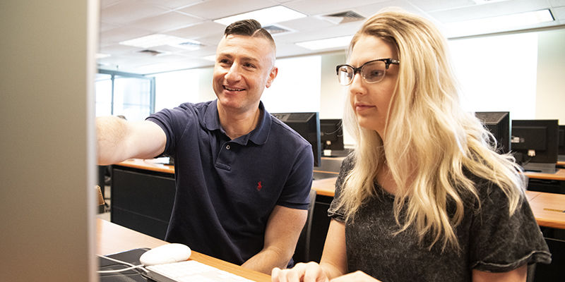 Dr. Aris Karagiorgakis, assistant teaching professor of Psychology, advises 2019 Erickson Discovery Grant recipient Kaylee Aaron. 