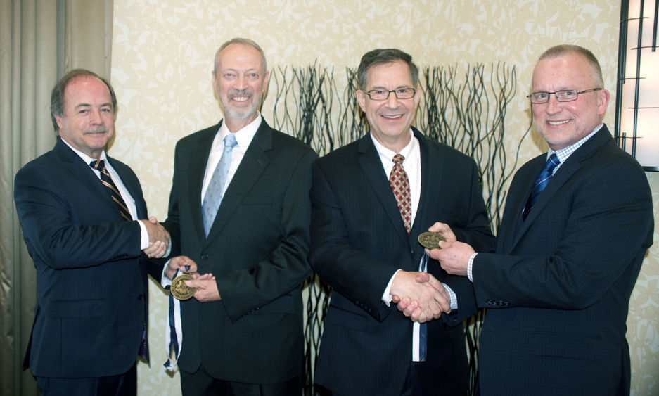 Outstanding Fellow Robert Eberly Jr. (second from left) Outstanding Alumnus Mark Kempic (third from left) receive medallions from Advisory Board of Penn State Fayette Inc. Chair Gary Monaghan (left) and Dr. Charles Patrick, chancellor and cao.