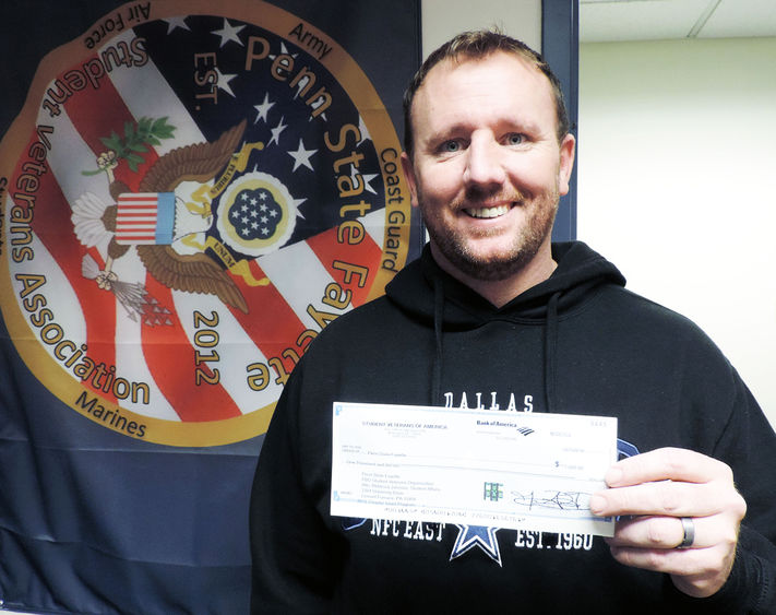  Dan Sparks, president of the Student Veterans Association at Penn State Fayette, The Eberly Campus, displays a $1,000 check for a chapter grant his organization recently received from Student Veterans of America.
