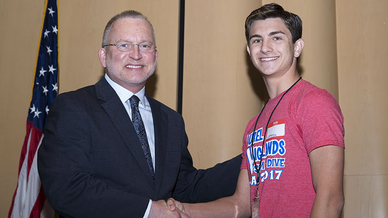 : Laurel Highlands High School senior and class treasurer Cameron Lizza welcomes Penn State Fayette, The Eberly Campus Chancellor and Chief Academic Officer Dr. Charles Patrick to the stage for his keynote address.