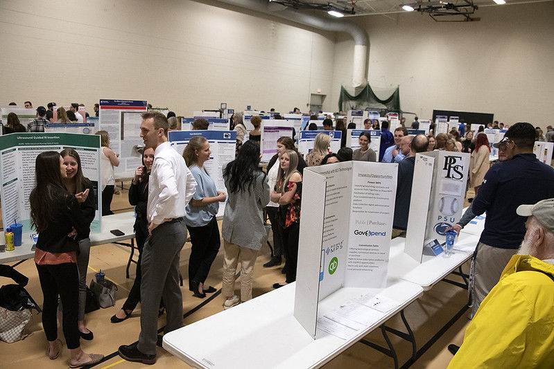 Students, faculty, and staff gather at the Spring 2022 Learning Fair in the auxiliary gym