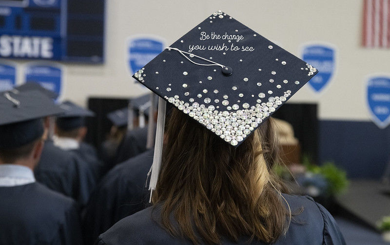 A graduation cap reads Be The Change You Wish to See