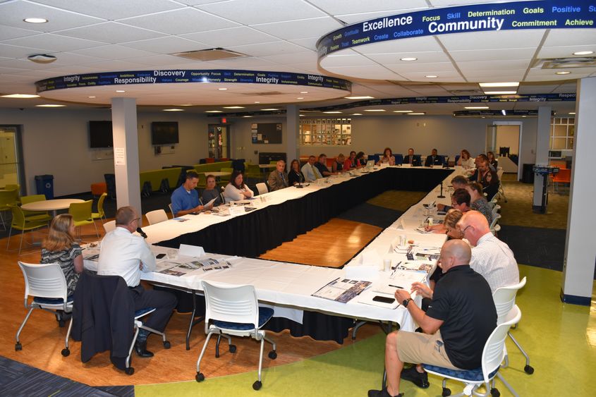 A forum of high school administrators and Penn State Fayette staff are seated around a large table in the Student Center.