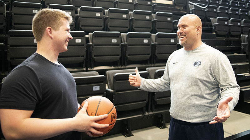 Joshua Crayton (left) and Lou Zadecky, athletic director (right) catch up off the court.