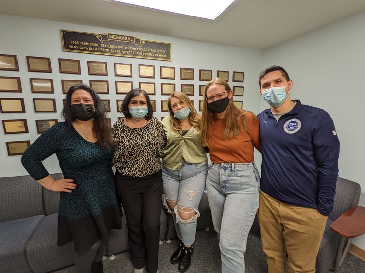 Corporate Communication professor poses with alumna and three current students