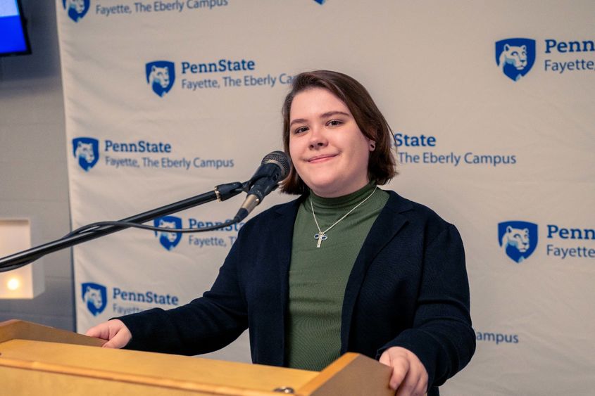 Skylar Wilson, a third-year psychology student at Penn State Fayette, The Eberly Campus, standing at the podium of the 15th annual Scholarship Donor Dinner. 