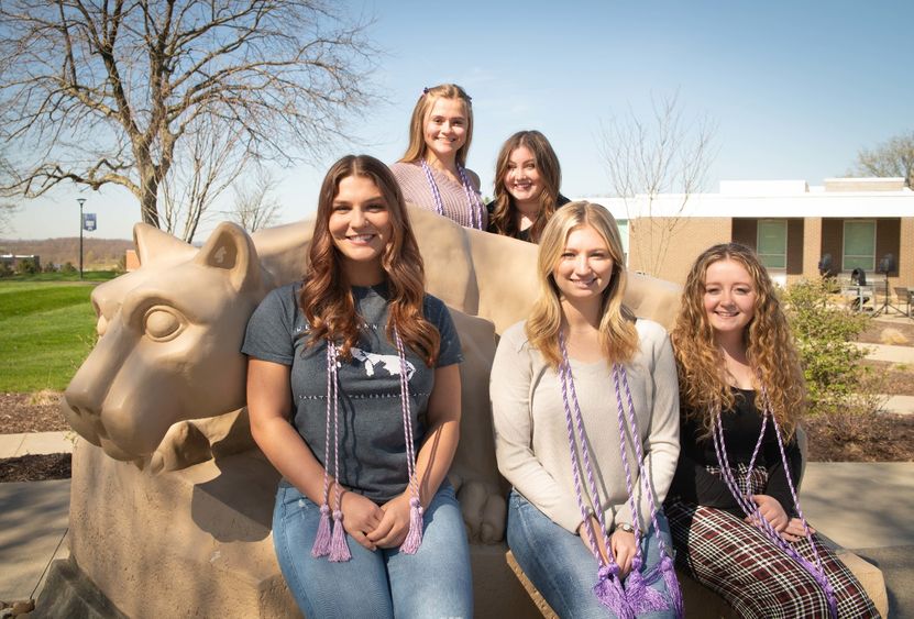 Students sitting next to the Penn State Fayette Nittany Lion shrine