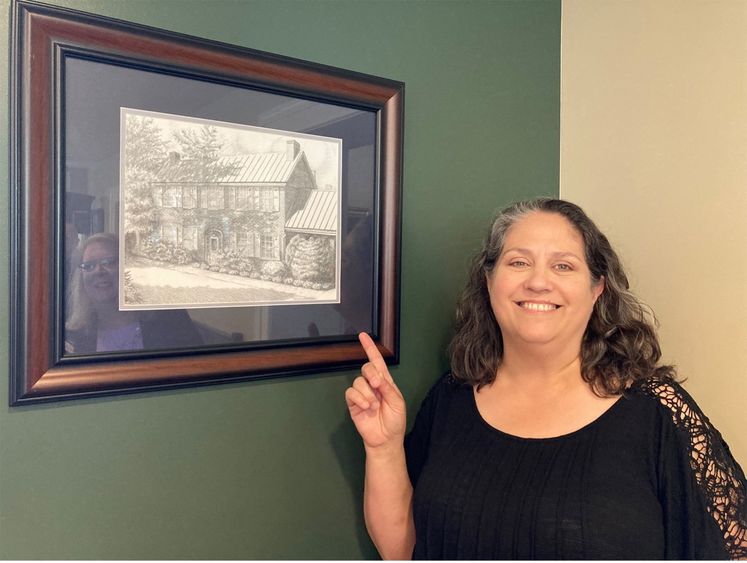 Michele George standing next to her artwork.