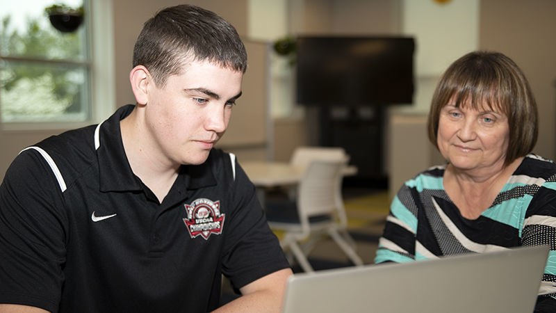 2021 retiree Rita Gumbert (right) assists a student in the Student-Athletes Graduate and Excel program.