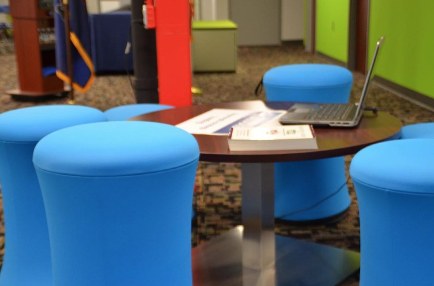 Blue stools surround a collaborative table at Fayette LaunchBox space