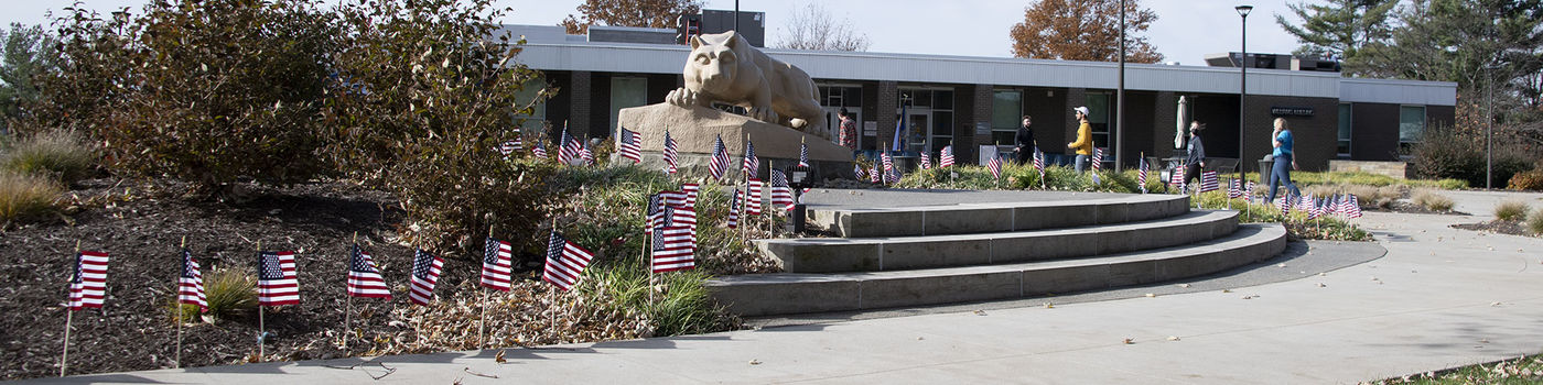 Veterans Day ceremony, lion shrine with American flags. 